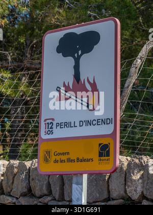 Un panneau espagnol avertit d'un risque d'incendie avec un arbre en feu et une allumette allumée, conseillant de rester loin du périmètre. Il vient du Govern de les Ille Banque D'Images