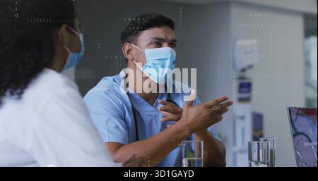 Médecin gestuel dans les gommages expliquant les résultats en clinique avec stéthoscope, ordinateur portable et dispositif médical Banque D'Images