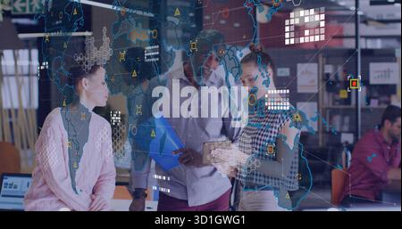 Trois professionnels collaborant dans le bureau de technologie avec des murs de verre, tablette, dossier bleu et ordinateur portable Banque D'Images