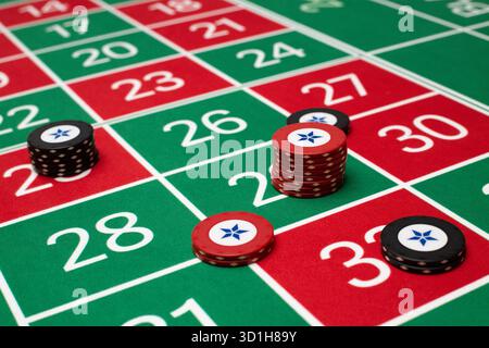 JEU, TABLE DE ROULETTE GÉNÉRIQUE, JETONS, STRATÉGIE : une table de roulette classique de joueur POV avec jetons disposés dans une stratégie de Paris commune dans un casino en direct. Banque D'Images