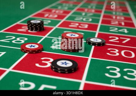 JEU, TABLE DE ROULETTE GÉNÉRIQUE, JETONS, STRATÉGIE : une table de roulette classique de joueur POV avec jetons disposés dans une stratégie de Paris commune dans un casino en direct. Banque D'Images