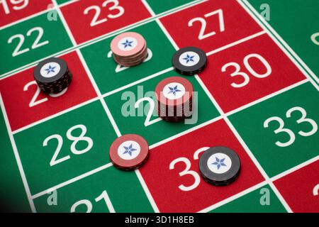 JEU, TABLE DE ROULETTE GÉNÉRIQUE, JETONS, STRATÉGIE : une table de roulette classique de joueur POV avec jetons disposés dans une stratégie de Paris commune dans un casino en direct. Banque D'Images
