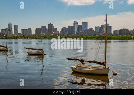 Cambridge, ma, États-Unis-15 juillet 2025 : vue de l'horizon de Boston depuis Cambridge avec le fleuve Charles et une rangée de petits voiliers au premier plan. Banque D'Images