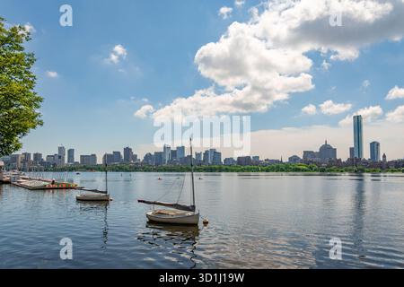 Cambridge, ma, États-Unis-15 juillet 2025 : vue de l'horizon de Boston depuis Cambridge avec le fleuve Charles et une rangée de petits voiliers au premier plan. Banque D'Images