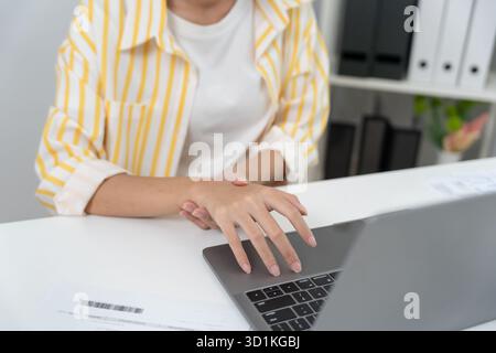 jeune femme d'affaires travaillant dans le bureau avec un syndrome du canal carpien ou l'inflammation de l'articulation du poignet, inflammation du muscle de la main du syndrome de bureau, main Banque D'Images