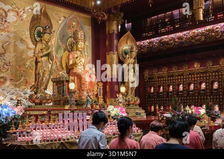 À l'intérieur du Temple de relique des dents de Bouddha, des statues dorées de divinités ornent les murs richement décorés. Banque D'Images