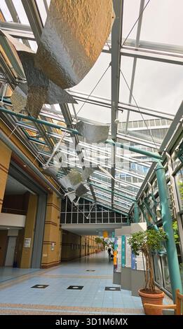 Belin, Allemagne - 30 mai 2025 : L'espace intérieur moderne dispose d'un toit en verre et de sculptures artistiques en métal suspendues au-dessus. Hôpital Banque D'Images