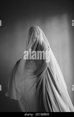 Femme avec une largeur de tissu blanc, costume fantôme Banque D'Images