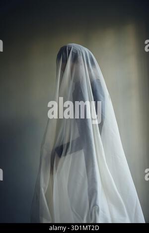 Femme avec une largeur de tissu blanc, costume fantôme Banque D'Images
