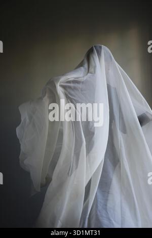 Femme avec une largeur de tissu blanc, costume fantôme Banque D'Images