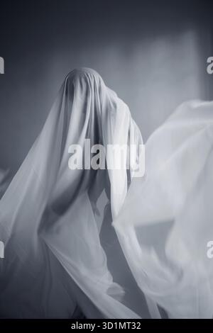 Femme avec une largeur de tissu blanc, costume fantôme Banque D'Images