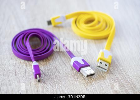 Gros plan d'un câble Micro USB violet et jaune sur une table en bois. Focus sélectif, Timiè™OARA, Roumanie Banque D'Images