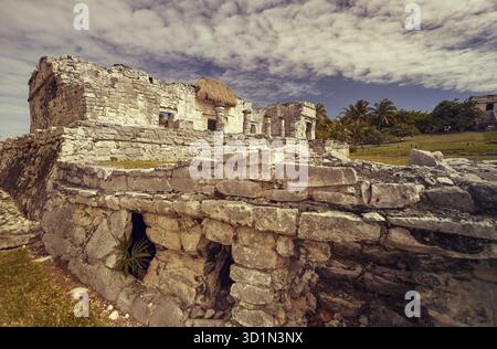 Vue latérale des vestiges d'un petit temple maya dans le complexe de Tulum au Mexique pris au coucher du soleil Banque D'Images