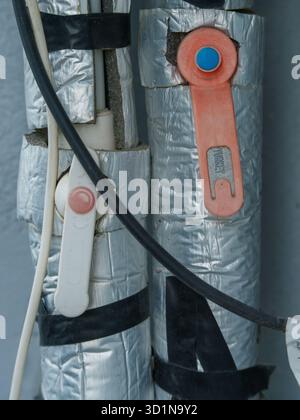 Tuyaux isolés avec vannes de régulation et câblage électrique Banque D'Images