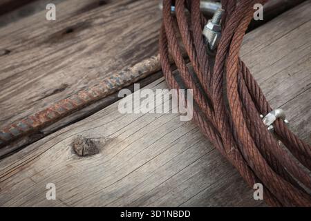 Câble de fer rouillé abstrait posé sur des planches de vieux bois Banque D'Images