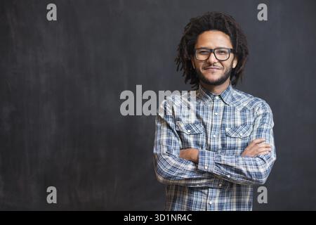 Jeune homme afro-américain beau gestuel posingon émotionnel tableau, hipster sur tableau Banque D'Images