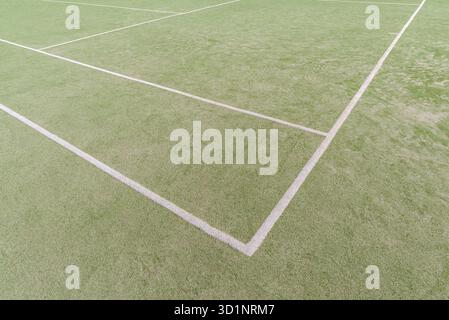 Gazon vert artificiel avec des lignes peintes en blanc sur un terrain de sport ouvert Banque D'Images