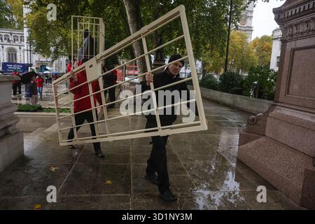 Londres, Royaume-Uni. 29 octobre 2025. Les militants de Greenpeace UK installent des cages de style prison autour des statues de Nelson Mandela, Mahatma Gandhi et Millicent Fawcett sur Parliament Square, Londres, Angleterre, le 29 octobre 2025. La manifestation met en lumière la répression du gouvernement britannique contre le droit de manifester en vertu de la récente législation, qui, selon les militants, menace les libertés civiles et la dissidence pacifique. (Photo de Pete Speller/Sipa USA) crédit : Sipa USA/Alamy Live News Banque D'Images