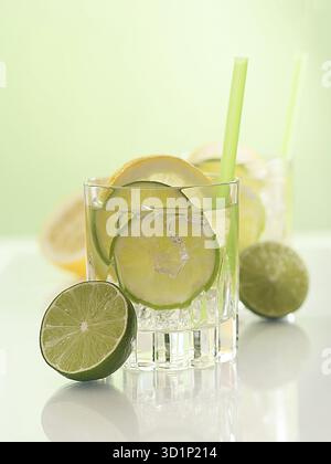 Cocktail avec citron vert, tranches de citron et glaçons Banque D'Images