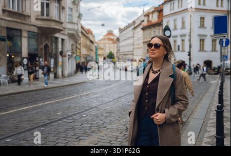 Femme élégante sur la rue pavée dans la ville européenne. Banque D'Images