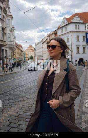 Femme élégante sur la rue pavée dans la ville européenne. Banque D'Images
