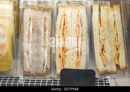Sandwichs présentés sur une étagère dans un marché avec différentes garnitures et différents types de pain Banque D'Images