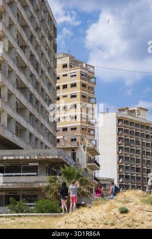 Famagouste, Chypre - 20 avril 2022 : les gens regardent les hôtels abandonnés près de la plage de la ville fantôme de Varosha Famagouste par une journée ensoleillée Banque D'Images