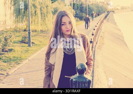 Portrait d'une belle fille contre l'eau, couleur de film, style instagram. Triste fille malheureuse à l'automne, stress, dépression Banque D'Images
