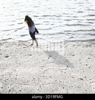 Jeunes femmes marchant sur le bord de mer. Vue arrière du corps entier beaucoup d'espace copyspace Banque D'Images