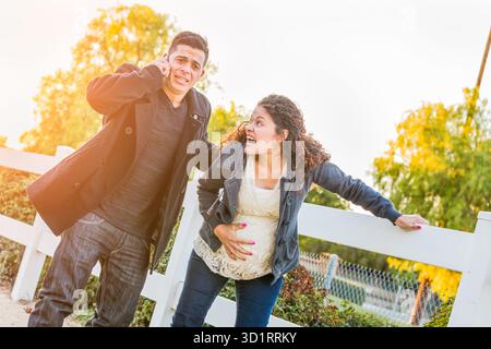 Étourdi Hispanic enceinte jeune couple dans la douleur marchant à l'extérieur Banque D'Images