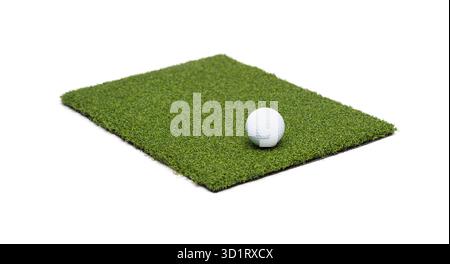 Balle de golf reposant sur une section de gazon artificiel sur fond blanc Banque D'Images