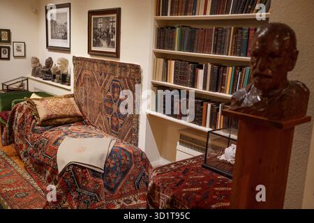 Buste en bois de Sigmund Freud et de son canapé psychanalytique dans son ancienne étude à sa maison du nord de Londres, le 29 octobre 2025, à Londres, en Angleterre. Psychanalyste Sigmund Freud (1865-1939) a vécu et travaillé ici au 20 Maresfield Gardens à Hampstead après avoir fui l'Autriche annexée aux nazis - mais après sa mort juste un an plus tard, c'est sa fille Anna Freud qui a continué à travailler ici en psychologie psychanalytique de l'enfant jusqu'à sa propre mort en 1982. Le musée Freud contient les archives Freud de livres et d'artefacts anciens des voyages de Sigmund Freud qu'il a pu apporter intacts quand Banque D'Images