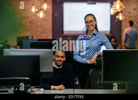 Collaboration numérique : femme d'affaires blonde et partenaire afro-américain examinant des documents en ligne Banque D'Images