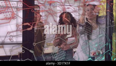 Collègues collaborateurs esquissant des schémas sur un tableau blanc en verre au bureau, avec des marqueurs et une tablette Banque D'Images