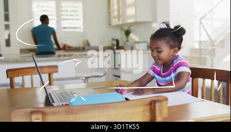 Fille de dessin tenant le marqueur rose à la table de cuisine familiale, avec ordinateur portable et étui à crayons, espace de copie Banque D'Images