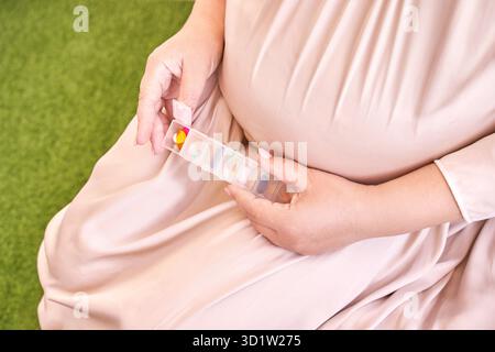 La femme enceinte mange des pilules de grossesse.Suppléments de grippe.Prendre des médicaments contre les allergies. Banque D'Images