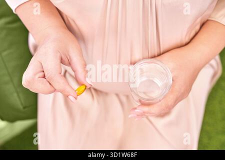 La femme enceinte mange des pilules de grossesse.Suppléments de grippe.Prendre des médicaments contre les allergies. Banque D'Images