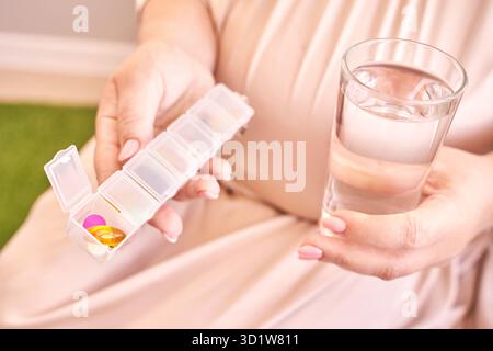 La femme enceinte mange des pilules de grossesse.Suppléments de grippe.Prendre des médicaments contre les allergies. Banque D'Images