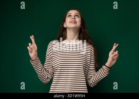 Femme debout devant le mur vert Banque D'Images