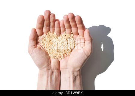 Un tas de riz en forme de cœur, symbolisant l'amour, l'unité et l'espoir. Les grains, divers Banque D'Images