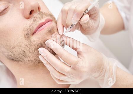 Injection au spa.Médecin mains dans des gants.Gros plan.Patient assez masculin Banque D'Images