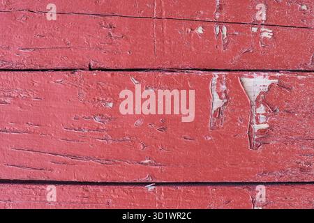 Planches de bois rouge altérées avec peinture pelable et fond de surface texturé Banque D'Images