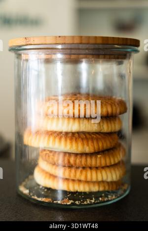 Pile de biscuits ronds dans un bocal en verre avec couvercle en bois Banque D'Images