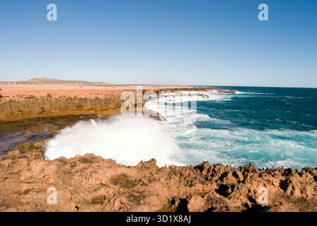 Les vagues s'écrasent sur les Blowholes de point Quobba, en Australie occidentale, où les vagues de l'océan explosent de façon spectaculaire les falaises marines. Banque D'Images