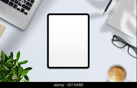 Vue de dessus de la tablette avec écran vierge, café, ordinateur portable, et plante sur le bureau lumineux moderne, prêt pour la maquette de conception numérique Banque D'Images