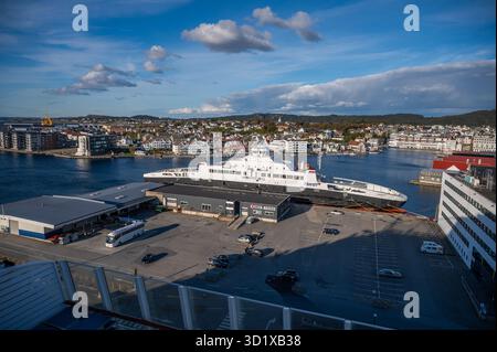 Un ferry fjord1 a accosté au port de Haugesund, en Norvège avec un paysage urbain en arrière-plan sous un ciel partiellement nuageux Banque D'Images