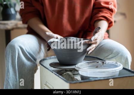 Maître de céramique bol de façonnage sur la roue de poterie en studio, créant des pièces à partir d'argile Banque D'Images
