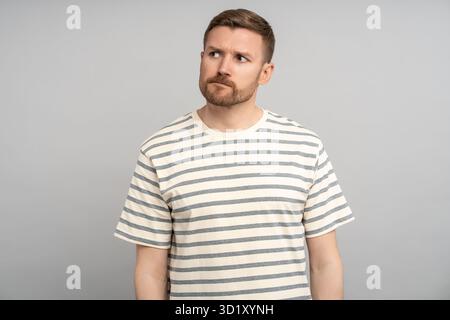 Homme d'âge moyen réfléchi avec une expression de visage perplexe douteuse dans l'hésitation, l'incertitude, le doute Banque D'Images