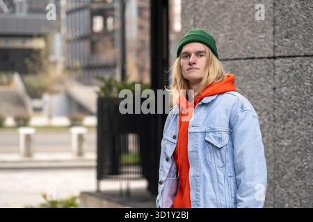 Portrait de rue de gars élégant confiant insouciant dans la tenue colorée à la mode regardant la caméra Banque D'Images