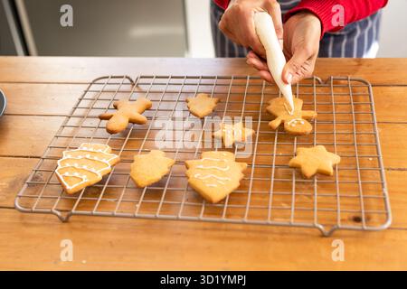 Glaçage blanc sur biscuit homme en pain d'épices sur une table en bois avec assortiment de biscuits glacés Banque D'Images